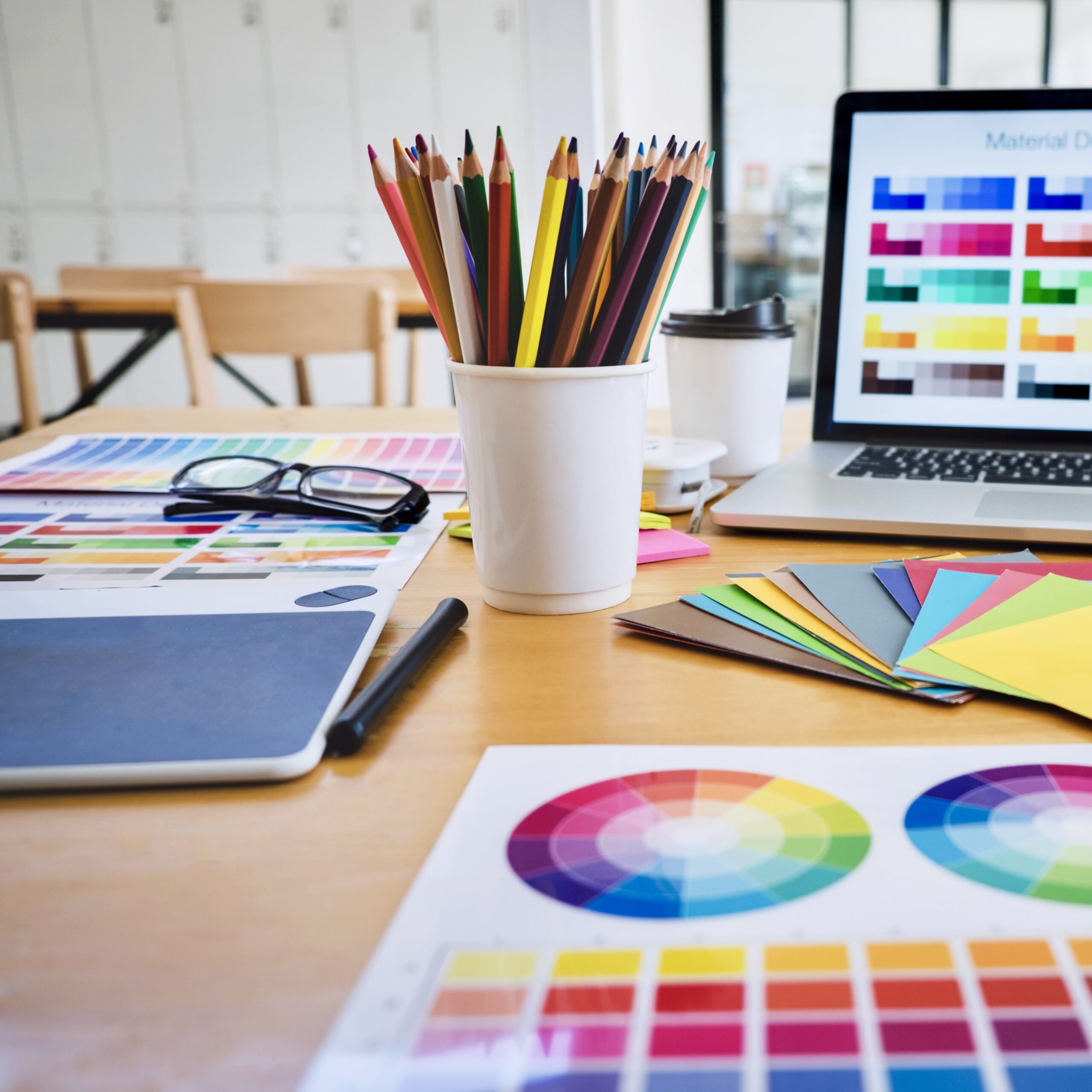 Graphic designer object tool and color swatch samples at workspace.